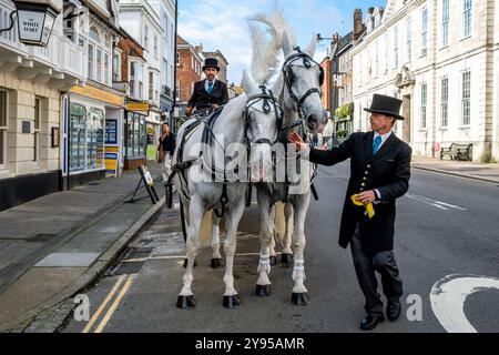 Un tradizionale pullman e cavalli parcheggiati nella High Street pubblicizza la grande riapertura dello storico White Hart Hotel, High Street, Lewes, Sussex, Regno Unito. Foto Stock