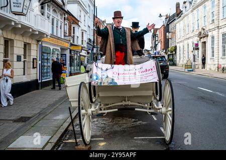 Un tradizionale pullman e cavalli parcheggiati nella High Street pubblicizza la grande riapertura dello storico White Hart Hotel, High Street, Lewes, Sussex, Regno Unito. Foto Stock