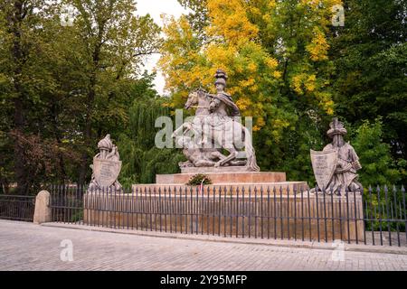 Statua del re Jan III Sobieski esposta in modo prominente in un parco pubblico. Il monumento è circondato da alberi verdi vibranti, che ne evidenziano il fascino storico Foto Stock