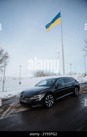 Vinnitsa, Ucraina - 22 gennaio 2024 : Volkswagen Arteon con bandiera Ucraina nel paesaggio urbano invernale Foto Stock