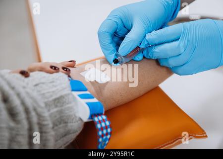 Il medico preleva il sangue dal paziente per il test medico. Laboratorio e diagnostica Foto Stock