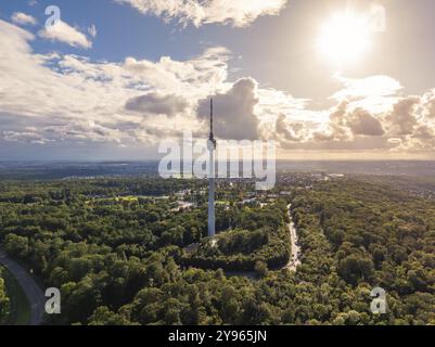 La torre della televisione sorge su una vasta area boschiva mentre il sole si infrangeva tra le nuvole, Stoccarda, Germania, Europa Foto Stock