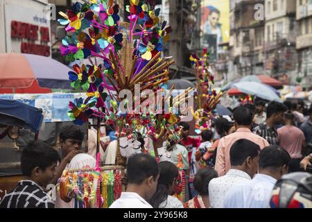 Il venditore vende giocattoli e altri oggetti per bambini in un mercato di strada prima del festival Durga Puja il 7 ottobre 2024 a Guwahati, in India. Shopping davanti a Du Foto Stock