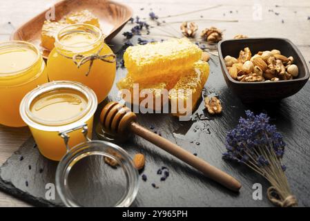 Nido d'ape su vassoio in ardesia con miele e noci sul tavolo della cucina, fotografia di cibo, fotografia di cibo Foto Stock