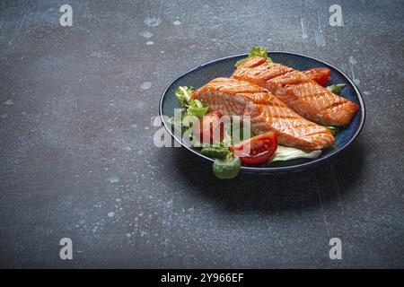 Carne di salmone alla griglia con insalata di verdure su piatto di ceramica su sfondo rustico, vista angolare, dieta bilanciata o pasto di insalata nutrizionale sana Foto Stock