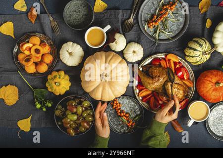 Composizione tavola festiva del Ringraziamento con tacchino arrosto, zucche, insalata di verdure, frutta, bevanda all'arancia. Cena per il giorno del Ringraziamento con tr Foto Stock