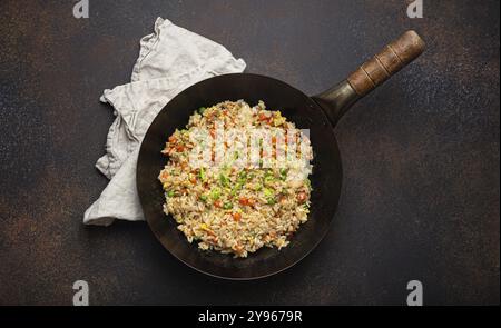 Autentico riso fritto cinese e asiatico con uova e verdure in una vista dall'alto del wok su uno sfondo rustico in cemento. Piatto tradizionale cinese, ph Foto Stock