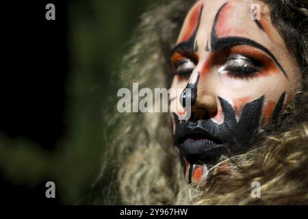 Primo piano di una donna in costume per la notte di Halloween che indossa trucco horror con gli occhi chiusi Foto Stock