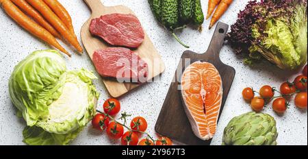 Prodotti alimentari assortiti: Verdure, bistecche di carne di manzo, filetto di salmone di pesce su taglieri di legno, vista rustica bianca da tavola. Cibo sano ingerito Foto Stock