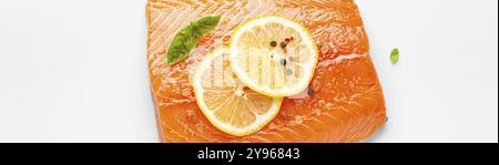 Filetto di salmone crudo fresco marmorizzato isolato su sfondo bianco con limone, sale grosso, erbe verdi vista dall'alto. Alimentazione sana e dieta equilibrata, cibo Foto Stock