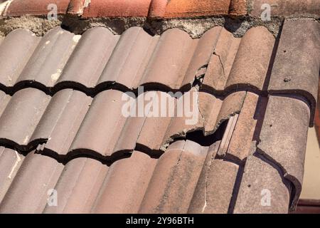 Vecchia tegola danneggiata che necessita di riparazione. Foto Stock