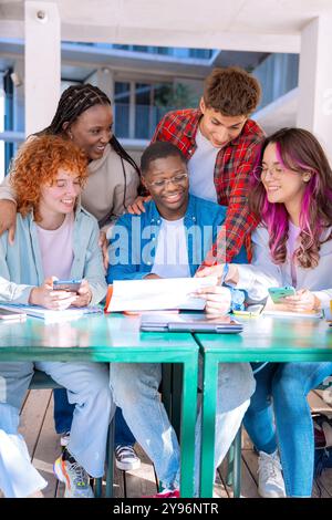 Felice gruppo variegato di studenti che studiano in biblioteca. Verticale Foto Stock
