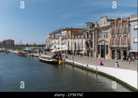 Aveiro, Portogallo - 11 settembre 2024: Barca colorata ormeggiata da edifici storici lungo l'acqua nella pittoresca cittadina durante il giorno Foto Stock