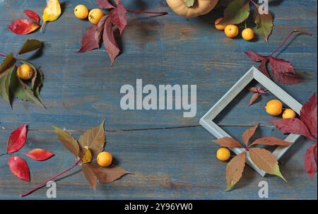 Cornice di foglie autunnali, frutta su tavola di legno. Vacanze e cibo. Sfondo per la progettazione. Foto Stock