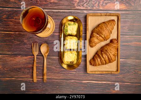 Insalata di caffè con muffin all'uovo e croissant su un tavolo di legno Foto Stock