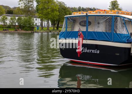 Poppa di barca «Hibernia» con bandiera e tenda in plastica sul Tamigi a Henley Foto Stock