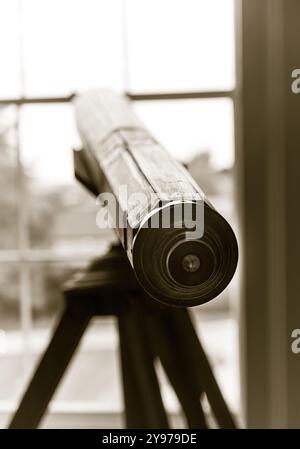 Un telescopio d'epoca che guarda fuori dalla finestra in una casa di campagna inglese. Foto Stock