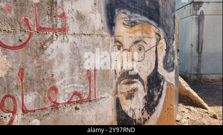 Graffiti di Hassan Nasrallah, fondatore e ex leader di Hezbollah su un muro in un villaggio nel sud del Libano Hezbollah è un partito politico islamista sciita libanese, un gruppo militare che è stato considerato come un movimento di resistenza, e un'organizzazione che fornisce servizi di assistenza sociale e di educazione religiosa. È un attore chiave nel sistema politico libanese e la sua ala politica, il partito lealtà al blocco della resistenza, detiene 15 seggi nel Parlamento libanese, mentre la sua ala paramilitare è il Consiglio della Jihad Foto Stock