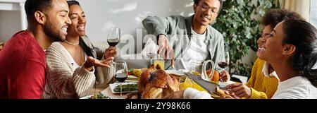 Un caldo raduno di amici che si gusta la cena del Ringraziamento, condividendo risate e cibo. Foto Stock