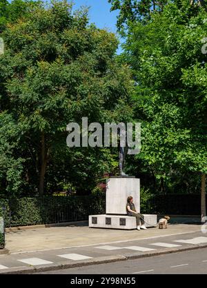 Londra - 06 15 2022: Veduta del parco di Belgrave Square con una donna con il suo cane seduto sulla statua di Simon Bolivar Foto Stock