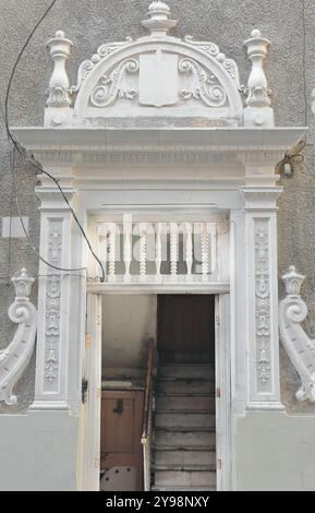 797 modanatura decorativa bianca che incornicia la porta di un edificio in stile eclettico in Calle Cuarteles Street, angolo con Plaza Angel Square. L'Avana-Cuba. Foto Stock