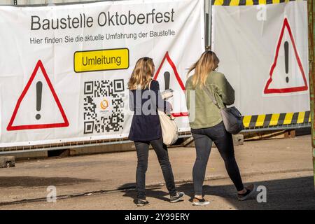 Abbau Oktoberfest, Transparent am Zaun der Baustelle, Passantinnen, Theresienwiese, München, Oktober 2024 Deutschland, München, 09.10.2024, Abbau Oktoberfest, Transparent am Zaun der Baustelle, Passantinnen, Wiesn, Bayern, bayerisch, *** Dismantling Oktoberfest, striscione alla recinzione del cantiere, passanti, Theresienwiese, Monaco di Baviera, ottobre 2024 Germania, Monaco di Baviera, 09 10 2024, demolizione dell'Oktoberfest, striscione presso la recinzione del cantiere, Passers-by, Wiesn, Baviera, Bavarese, Foto Stock