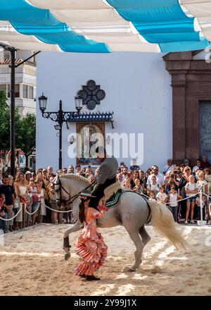 Fuengirola, Malaga, Spagna. Cavaliere e ballerino in abito e cappello rosa di flamenco, che esegue una ricreazione di una danza di sevillanas durante la fiera Foto Stock