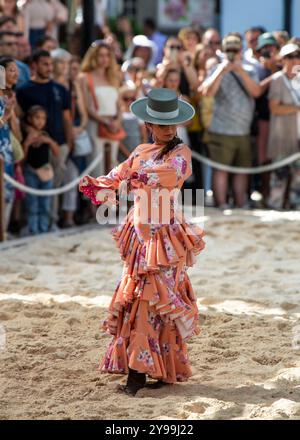 Fuengirola, Malaga, Spagna. Cavaliere e ballerino in abito e cappello rosa di flamenco, che esegue una ricreazione di una danza di sevillanas durante la fiera Foto Stock