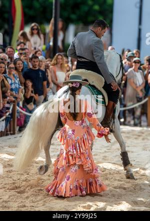 Fuengirola, Malaga, Spagna. Cavaliere e ballerino in abito e cappello rosa di flamenco, che esegue una ricreazione di una danza di sevillanas durante la fiera Foto Stock