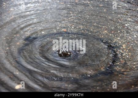 Sistema di drenaggio a pioggia pesante scarico pozzetto di ferro acqua di inondazione che sgorga verso l'alto infrastruttura urbana sopraffatta acque piovane potente flusso d'acqua Gola di scoppio Foto Stock