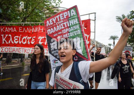 Atene, Grecia. 5 ottobre 2024. Un manifestante marcia con il pugno alzato con un cartello con lo slogan pro-Palestina. Centinaia di manifestanti hanno marciato per le strade di Atene contro le guerre e in solidarietà con Libano e Palestina, in Grecia, il 5 ottobre 2024. (Foto di Dimitris Aspiotis/Pacific Press/Sipa USA) credito: SIPA USA/Alamy Live News Foto Stock
