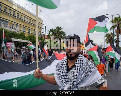 Atene, Grecia. 5 ottobre 2024. I manifestanti hanno una bandiera palestinese gigante e gridano slogan. Centinaia di manifestanti hanno marciato per le strade di Atene contro le guerre e in solidarietà con Libano e Palestina, in Grecia, il 5 ottobre 2024. (Foto di Dimitris Aspiotis/Pacific Press/Sipa USA) credito: SIPA USA/Alamy Live News Foto Stock