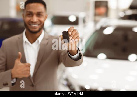 Manager Irriconoscibile Che Mostra Le Thumbs-Up Di Key Gesturing In Store, Profondità Poco Profonda Foto Stock