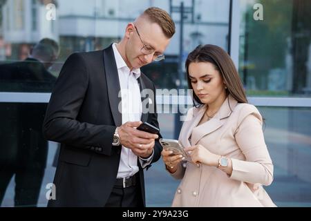 Giovani professionisti impegnati in conversazione all'esterno di un edificio moderno. Foto Stock