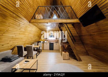 Cabina interna moderna in legno con cucina e zona loft, perfetta per rilassarsi e rifugi accoglienti Foto Stock