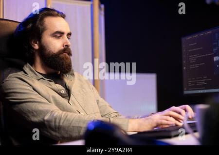 Informatico che aggiorna l'algoritmo di apprendimento automatico dell'intelligenza artificiale, scrivendo script di codice binario. Lo specialista IT negli uffici di appartamenti utilizza la programmazione per aggiornare l'intelligenza artificiale Foto Stock