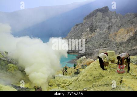 Minatori di zolfo nel cratere ijen, cratere di montagna situato a un'altitudine di 2,386 mdpl, è ancora attivo oggi e ha il potenziale di sputare lava. Foto Stock