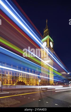 Big Ben la sera. Dabldekker passa e lascia una linea di luce a basse velocità dell'otturatore. Obiettivo inclinabile/inclinato scattato, riposto verticalmente Foto Stock