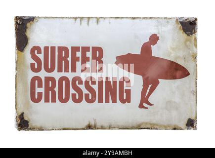 Grungy retro Vintage Surfer Crossing Sign at A Road Crossing by A Beach Foto Stock