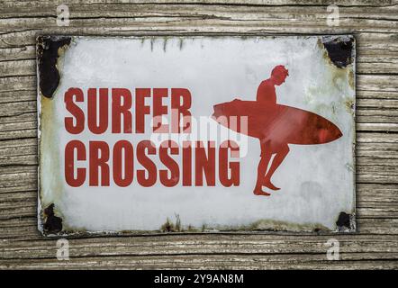 Cartello di avvertimento rosso vintage retro Surfer Crossing su sfondo in legno alle Hawaii Foto Stock