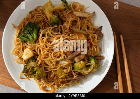 Spaghetti all'uovo in stile Hong Kong saltati in padella con carne e verdure Foto Stock