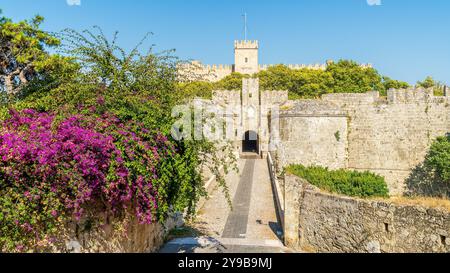 La porta di Amboise a Rodi presenta un mix impressionante di architettura medievale e bellezza naturale, con mura di pietra della fortezza e fiori vivaci, perfetto per te Foto Stock