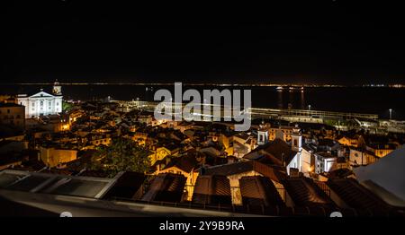 Ammira Alfama e il fiume Tago da mirante de Santa Luzia di notte - Lisbona, Portogallo Foto Stock