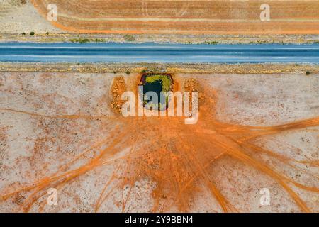 Vista aerea delle piste per animali che conducono ad una diga di fattoria accanto ad una strada di campagna a Moolort nel Victoria centrale, Australia Foto Stock