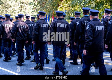 New York, Stati Uniti. 09 ottobre 2024. I membri della FDNY che indossano giacche FCNY marciano accanto al banco di osservazione. La FDNY tenne il suo 117° Memorial Day a Riverside Park per onorare 14 membri morti nell'ultimo anno, due dei quali fecero il sacrificio supremo, morendo in linea di dovere. Migliaia di membri e famiglie in uniforme, così come il sindaco Eric Adams, si sono riuniti al Firemen's Memorial nel parco per la cerimonia. Credito: SOPA Images Limited/Alamy Live News Foto Stock