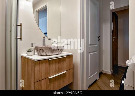 Un bagno moderno ed elegante con arredi eleganti e splendidi elementi in legno naturale Foto Stock