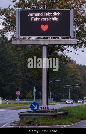 Qualcuno ti ama! Guidare con cautela. Da aprile, 17 segnali stradali digitali a Colonia sono stati temporaneamente adornati con detti umoristici Foto Stock