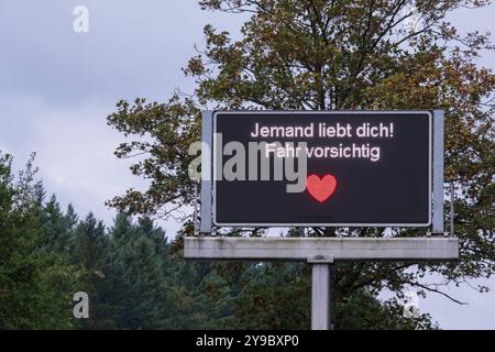 Qualcuno ti ama! Guidare con cautela. Da aprile, 17 segnali stradali digitali a Colonia sono stati temporaneamente adornati con detti umoristici Foto Stock