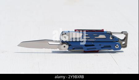 Coltello multiutensile Leatherman Signal blu e argento con impugnatura blu. Il coltello si trova su una superficie bianca Foto Stock