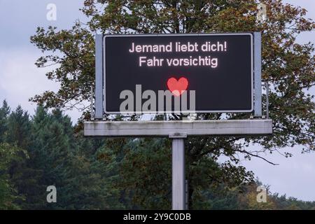 Jemand liebt Dich Fahr vorsichtig. Seit April schmücken 17 digitale Verkehrstafeln in Köln zeitweise humorvolle Sprüche auf Kölsch. Diese Botschaften, die normalerweise für Verkehrsinfos genutzt werden, erscheinen nur, wenn keine Staus oder Gefahren gemeldet werden müssen. Insgesamt werden drei verschiedene kölsche Nachrichten für die Autofahrerinnen und Autofahrer angezeigt. *** Qualcuno ti ama guidare con attenzione. Da aprile, 17 segnali stradali digitali a Colonia sono stati temporaneamente adornati con canti umoristici a Kölsch. Questi messaggi, che vengono normalmente utilizzati solo per le informazioni sul traffico Foto Stock